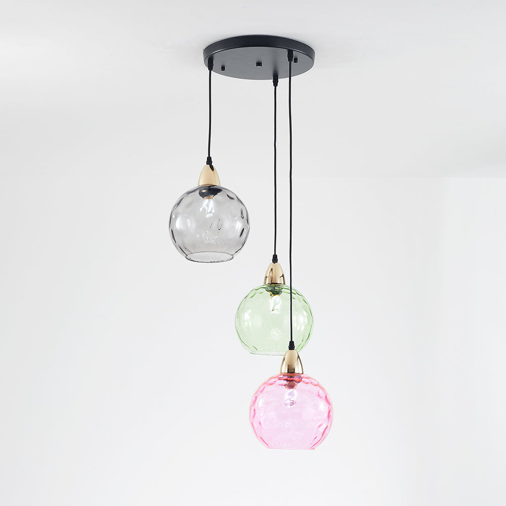 Smoke-grey, pale green and pink glass globes at staggered heights beneath a round black canopy