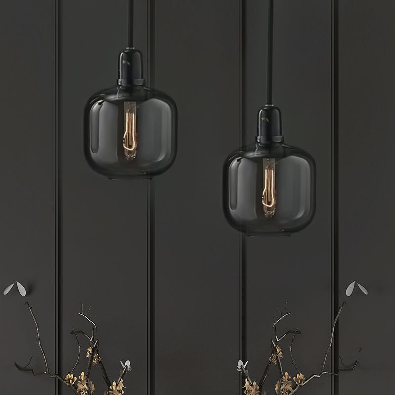 Pair of wide smoke-gray glass pendants against a dark wall