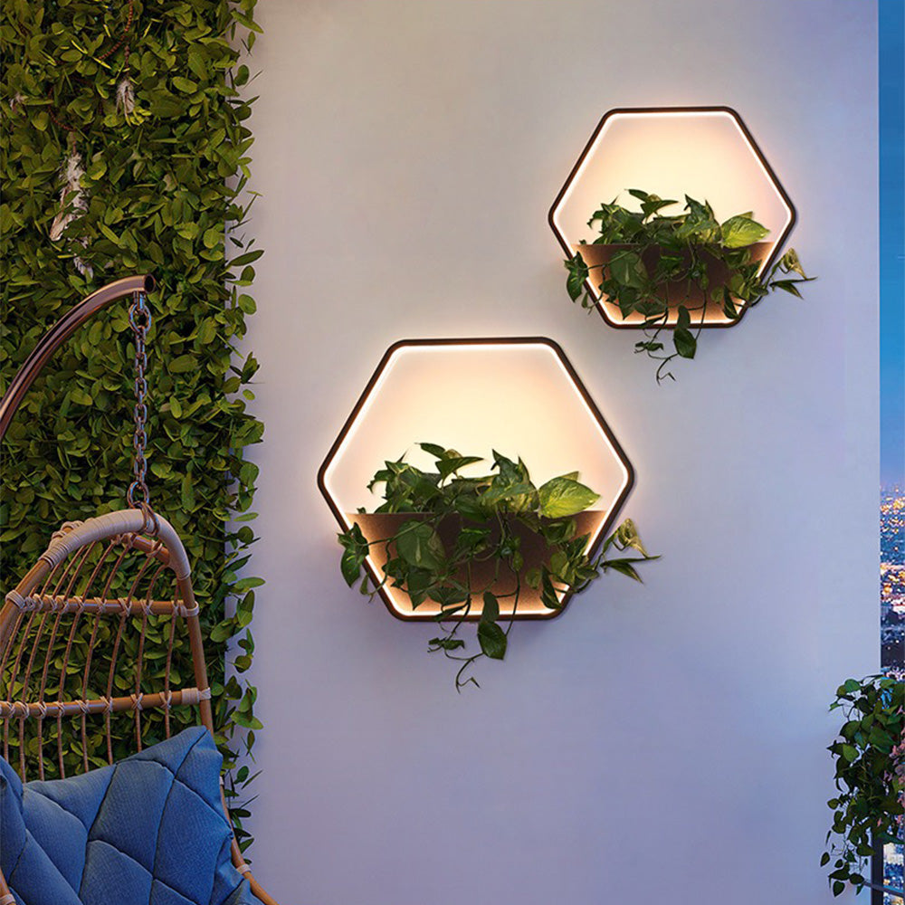Two Orr hexagonal shelf lights with plants on an exterior wall beside a hanging chair.