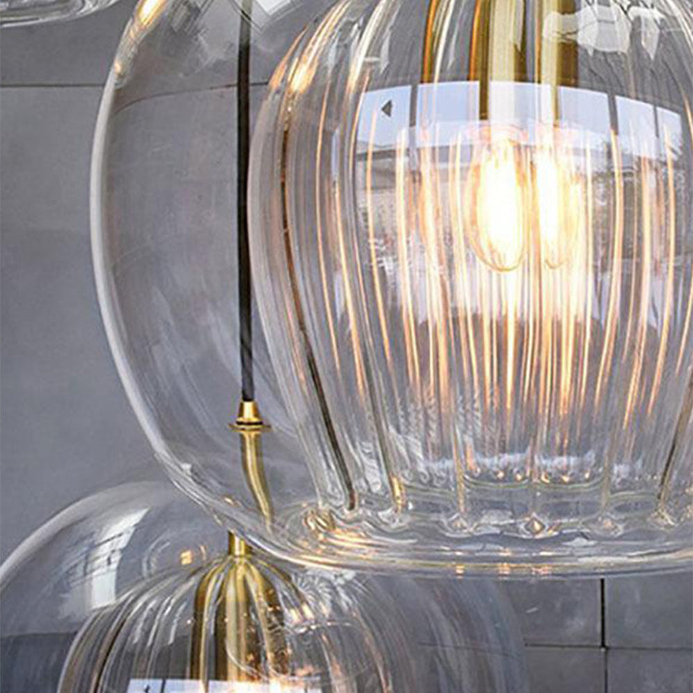 Close clear globe and ribbed inner shade with a lit bulb and gold-tone fitting