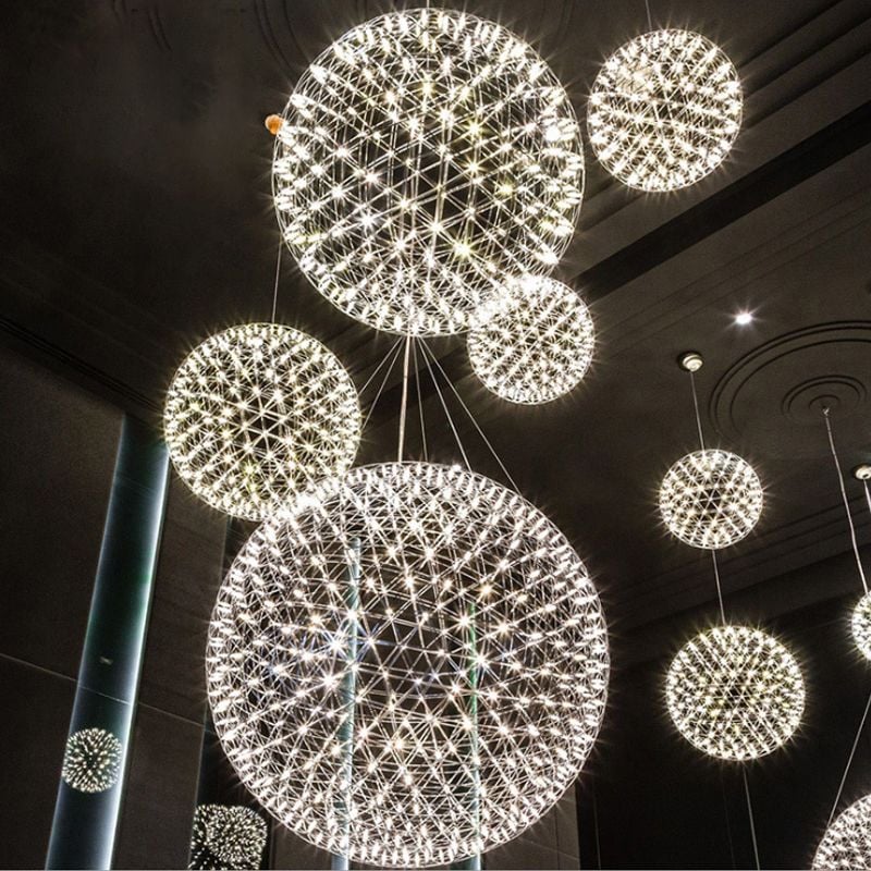 Group of illuminated silver firework-style pendants at different heights