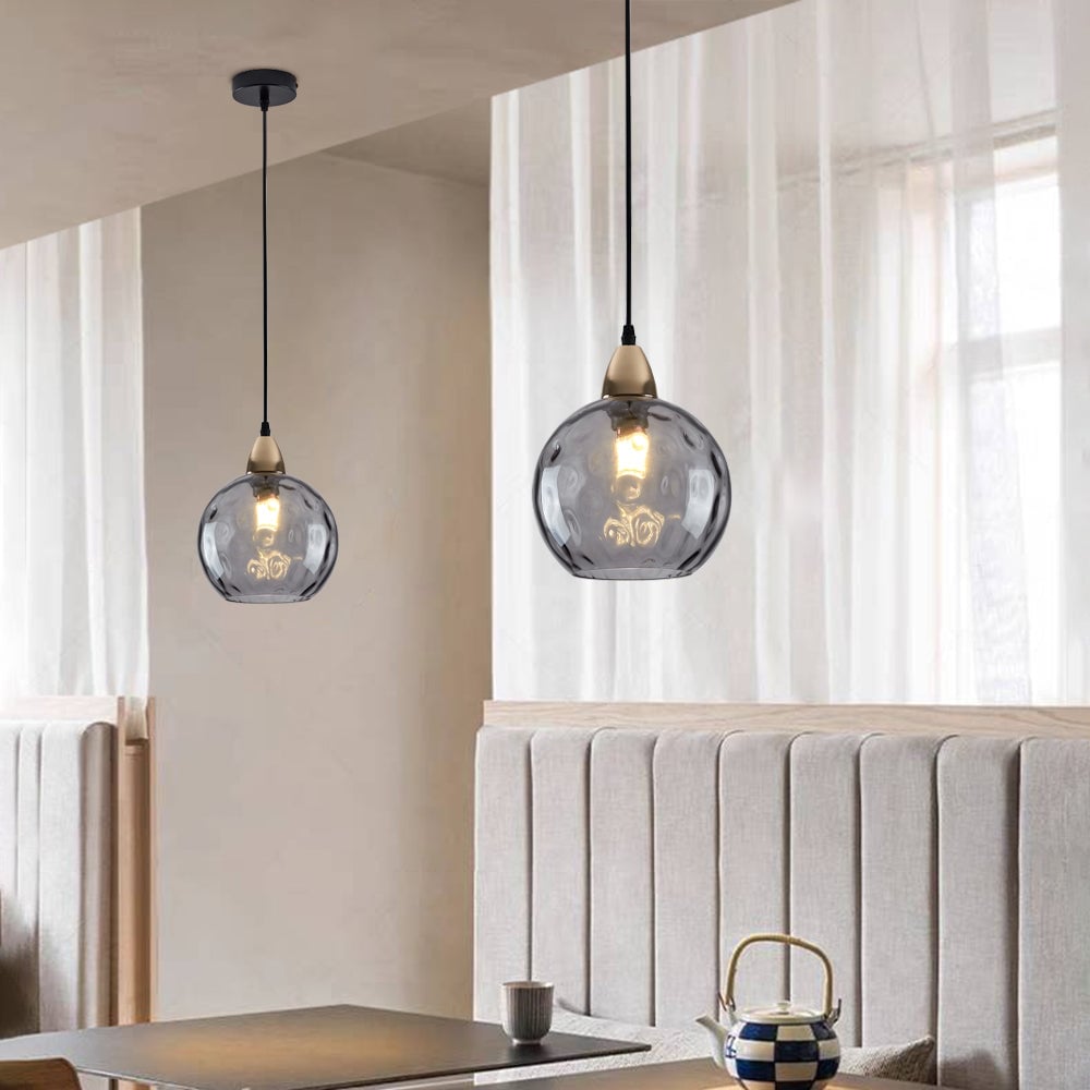 Grey glass globe pendants above a banquette with black ceiling plate