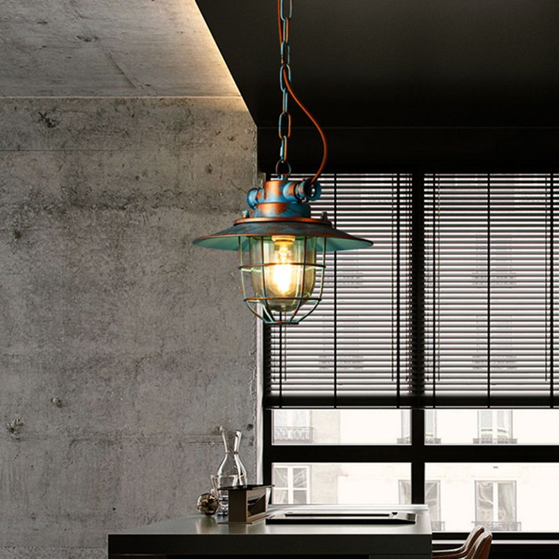 Blue Alessio pendant against concrete walls and a dark window blind