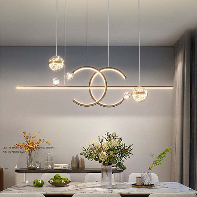 Illuminated Madina double-C pendant above a kitchen dining surface