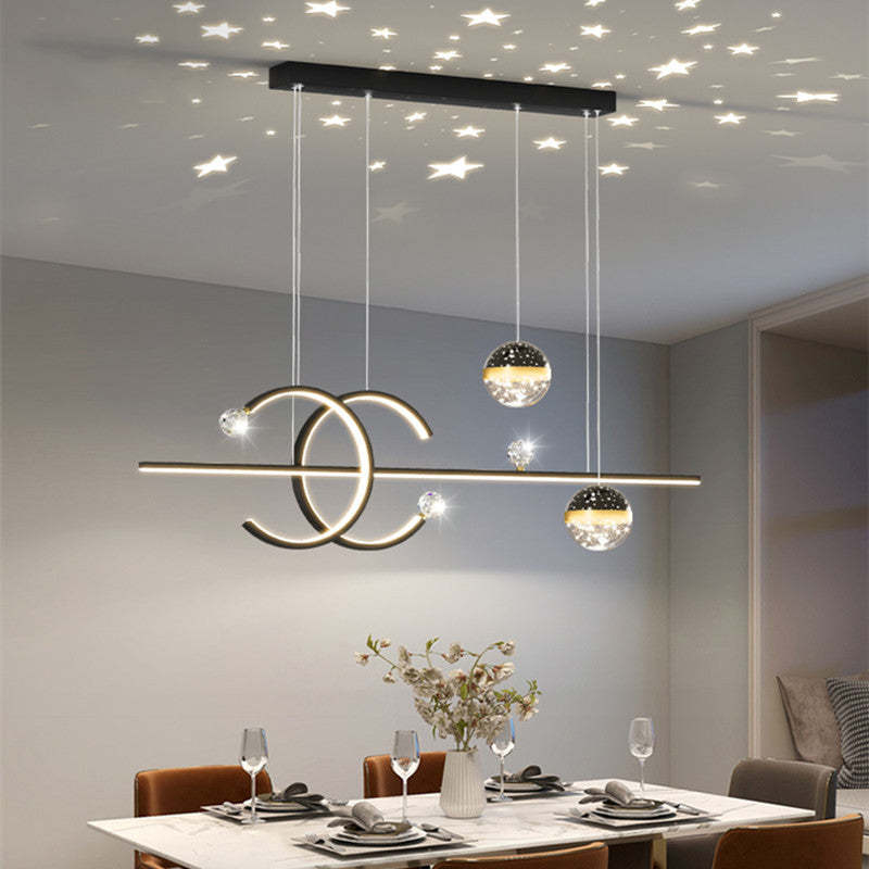 Lit dark-frame Madina pendant above a dining table, with two globe shades and stars pictured on the ceiling