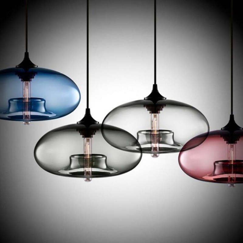 Four separate Blue, Gray-toned and Pink glass pendants partly cropped against a Dark gradient background