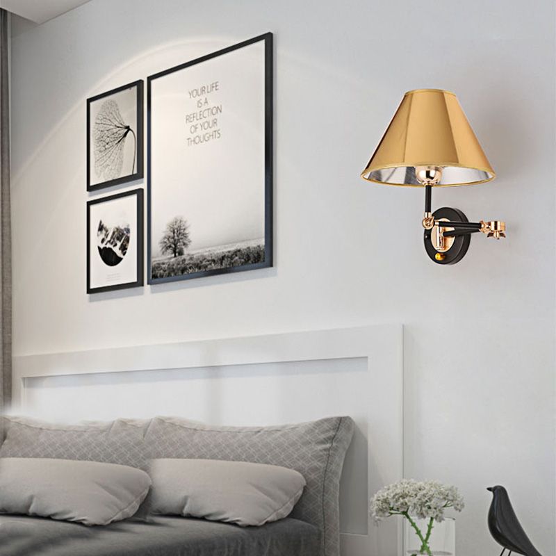 Gold Carins wall light mounted beside a bed and framed pictures.