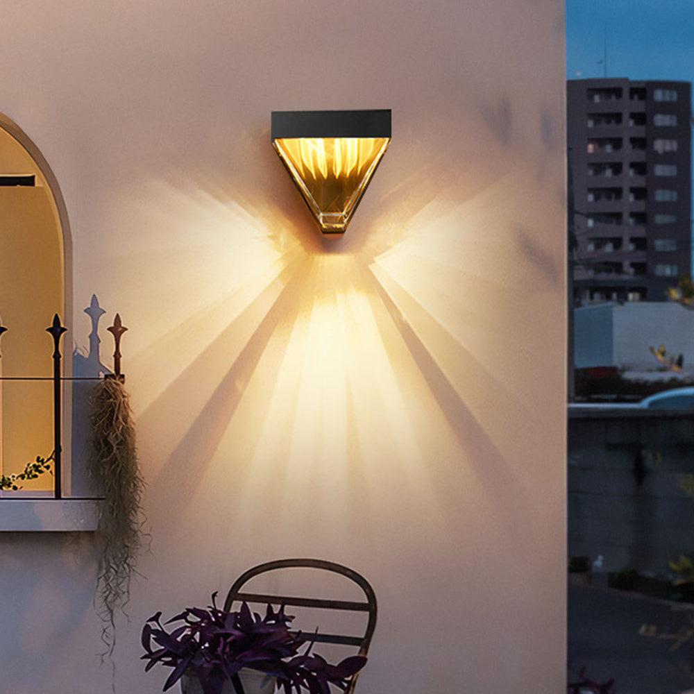 Orr wall lamp casting a fan of warm light above an outdoor table