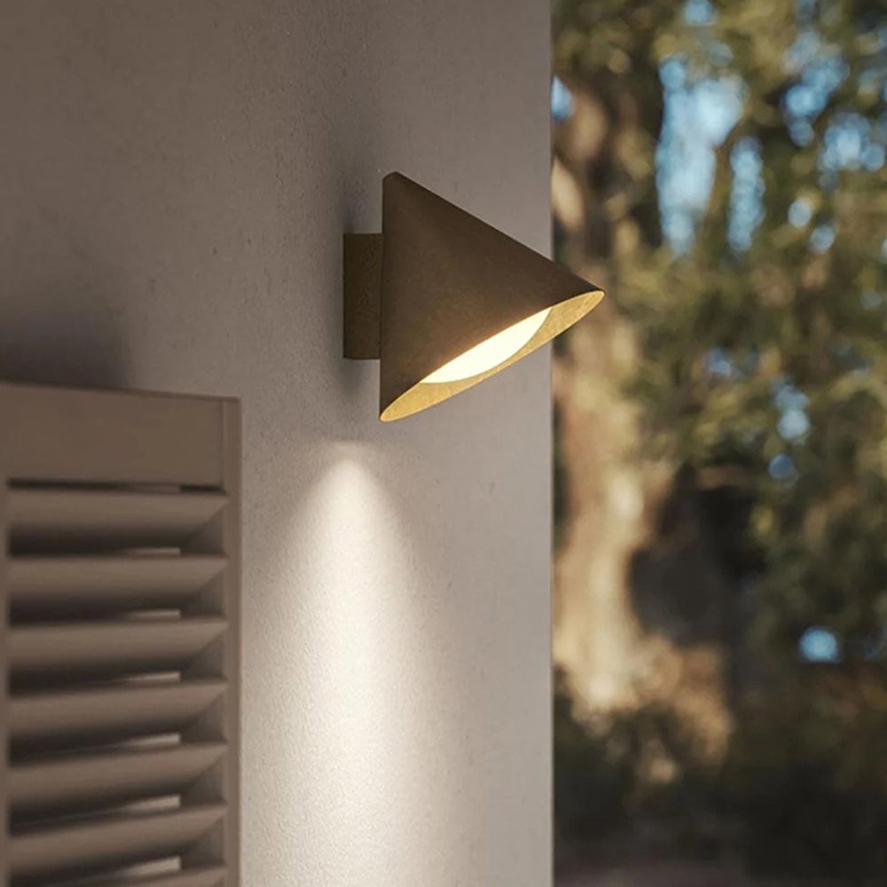 Carins Gold H 9.5-inch compact angled cone wall light close to a wall beside shutters