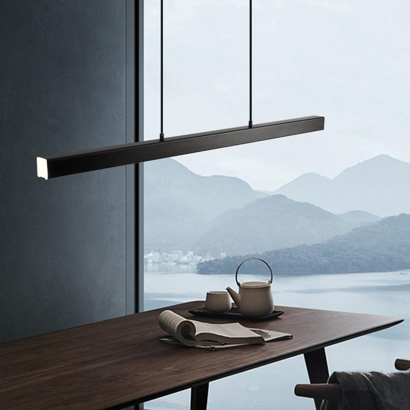 Black Edge pendant angled above teapot and newspaper on wooden table beside a misty mountain-view window