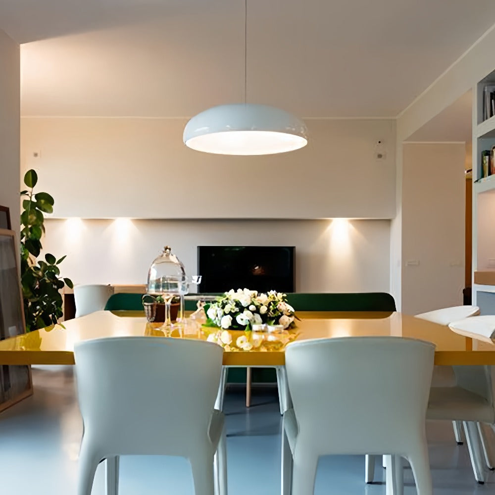 White dome pendant over a glossy yellow dining table with pale chairs and a green bench