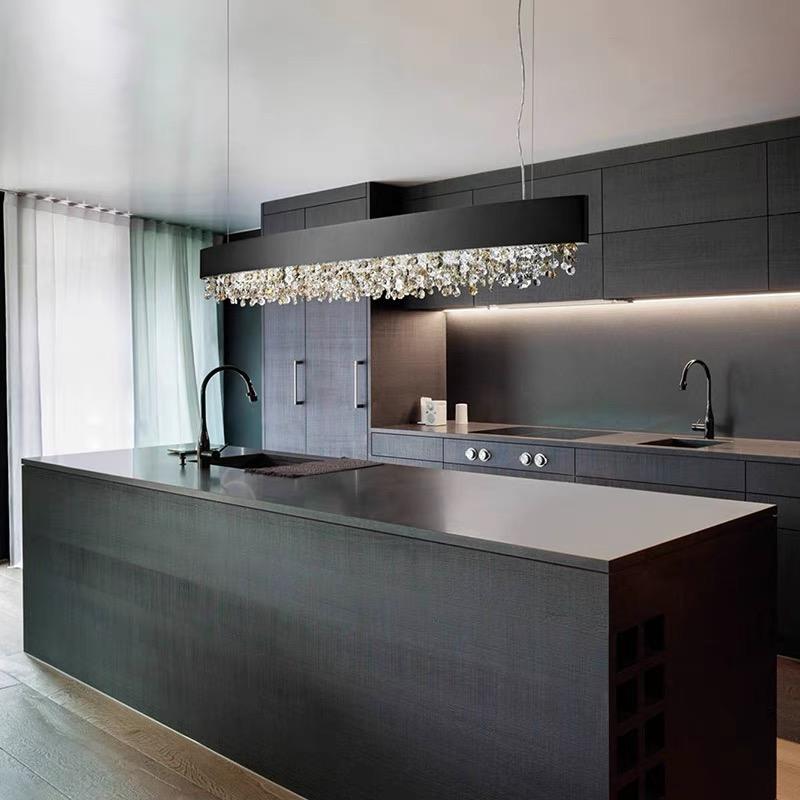 Black crystal pendant suspended over a dark kitchen island