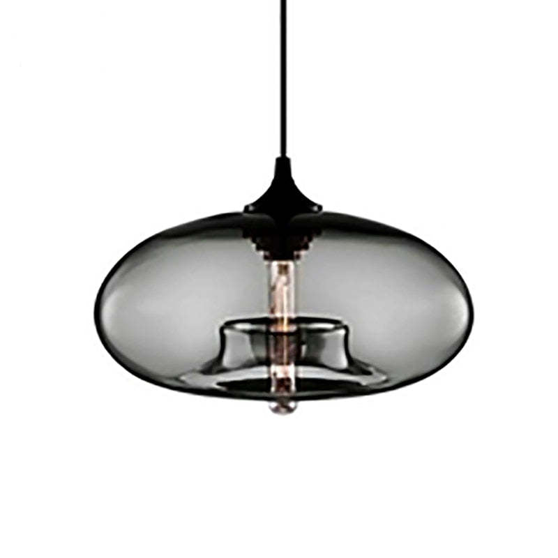 Smoke Gray oval glass pendant light with Black cap, cable and visible central bulb against a White background