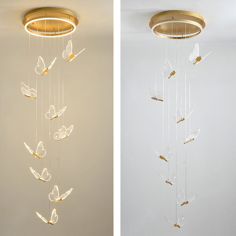 Side-by-side nine-butterfly Olivia cascades beneath gold-tone canopies, left glowing warmly and right appearing paler