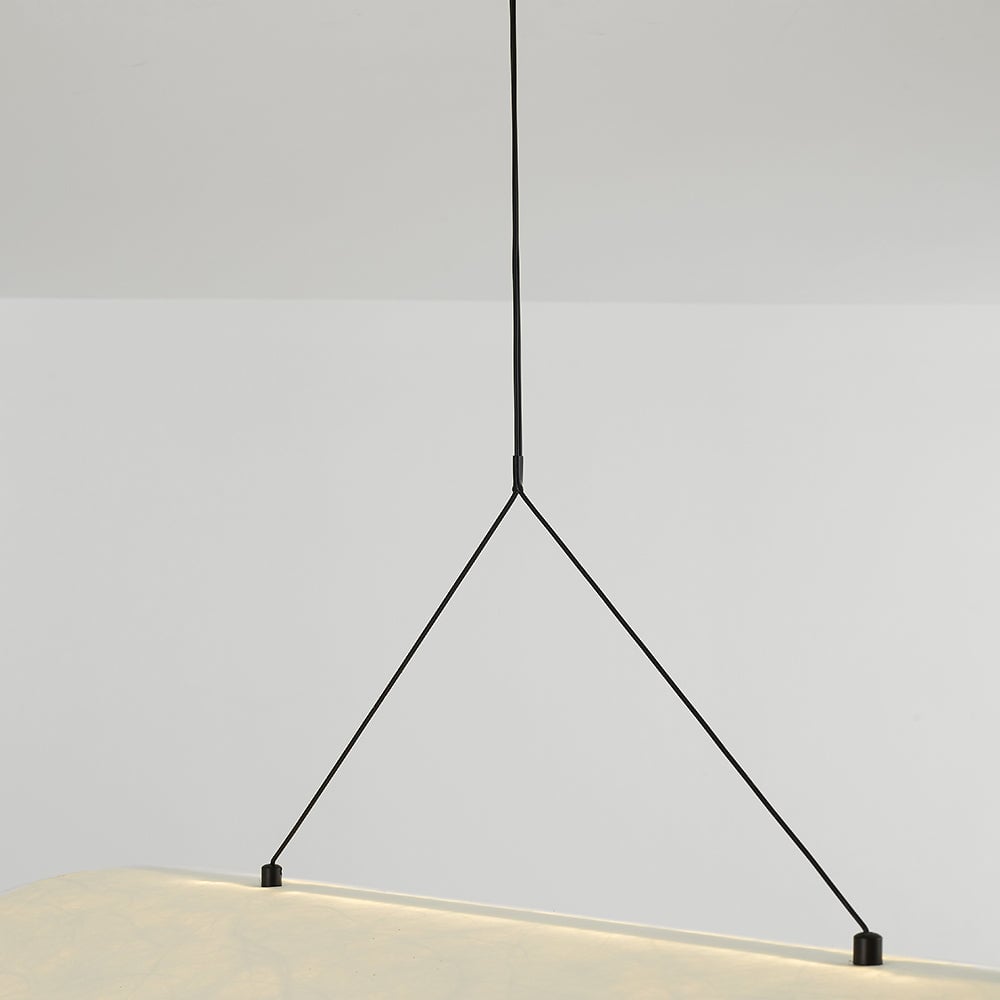 Detail of the black suspension wire splitting into two supports attached to the white shade