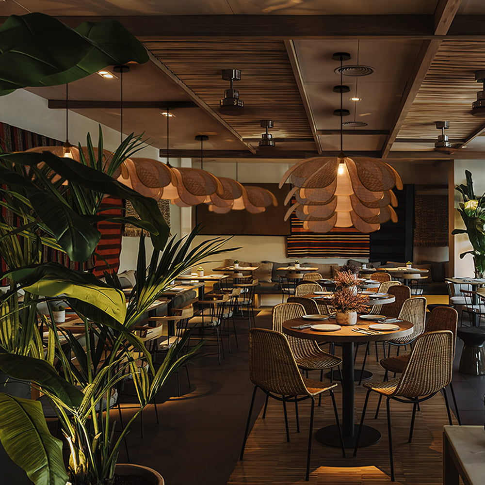 Ritta woven flower pendant among dining tables and other lamps in a plant-filled interior