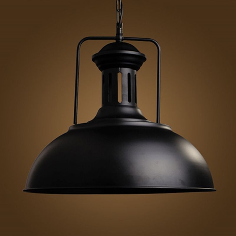 Black Alessio dome pendant with a slotted upper section, squared bracket and hanging chain against a brown background
