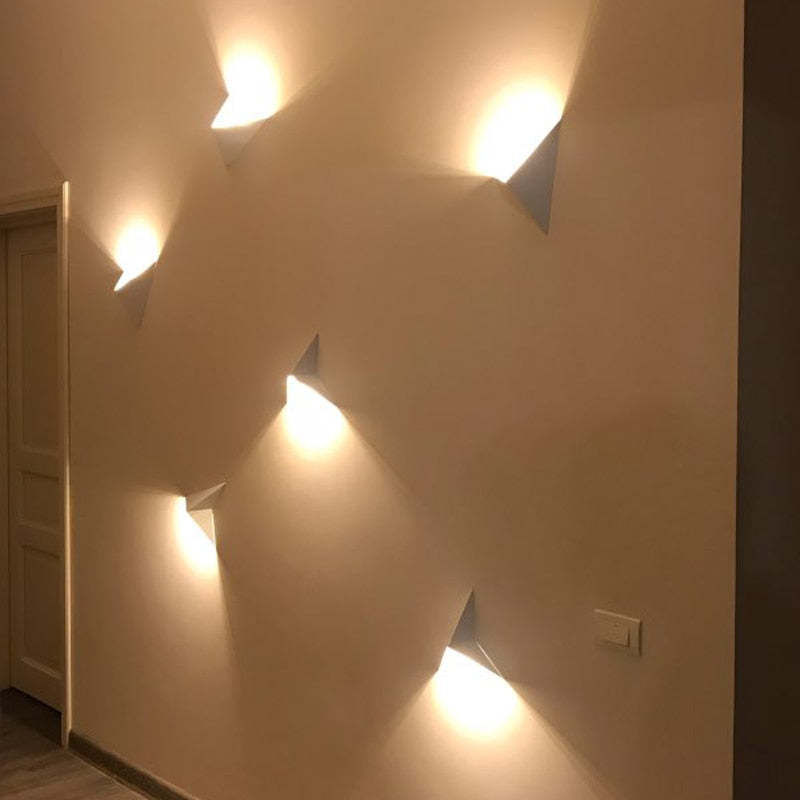 Five Orr triangular wall lights arranged across a hallway wall