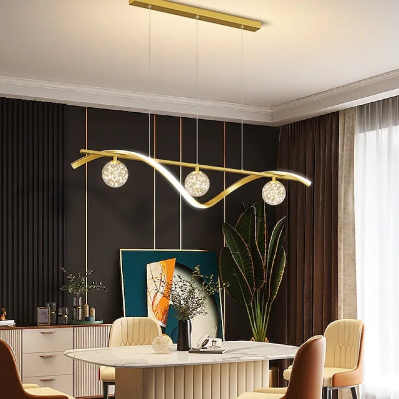 Gold three-globe wave pendant above a dining table