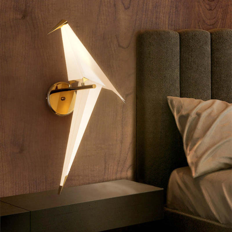 Single illuminated Clifford bird on a round gold-tone plate beside a bed and dark floating shelf
