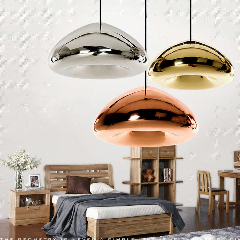 Silver, gold and rose-gold reflective dome pendants pictured above a bedroom arrangement