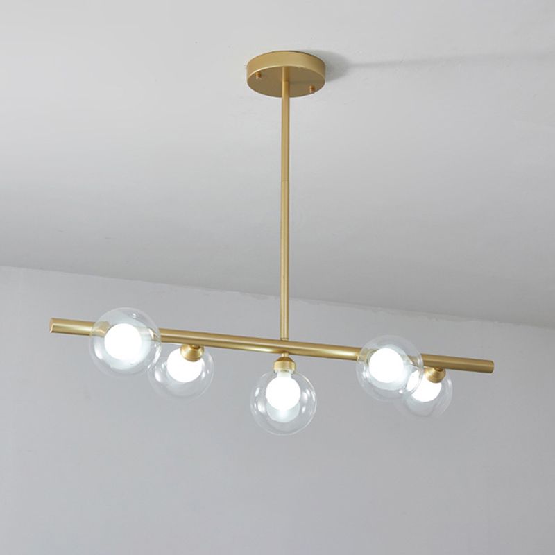 Close gold five-globe pendant showing bar, upright suspension and round canopy against a pale ceiling