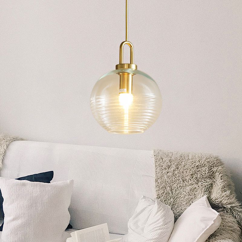 Clear rounded Sanna C pendant above a sofa