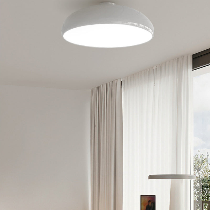 Illuminated white Morandi dome ceiling light above pale curtains beside a window