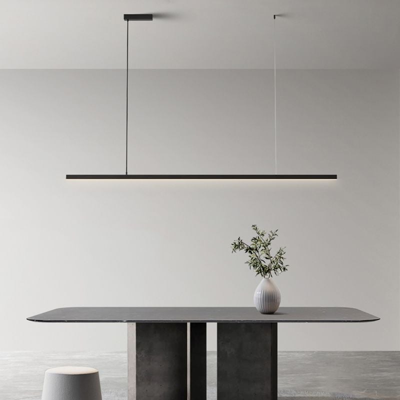 Black Edge linear pendant above gray dining table with white plant vase, gray stool and rug