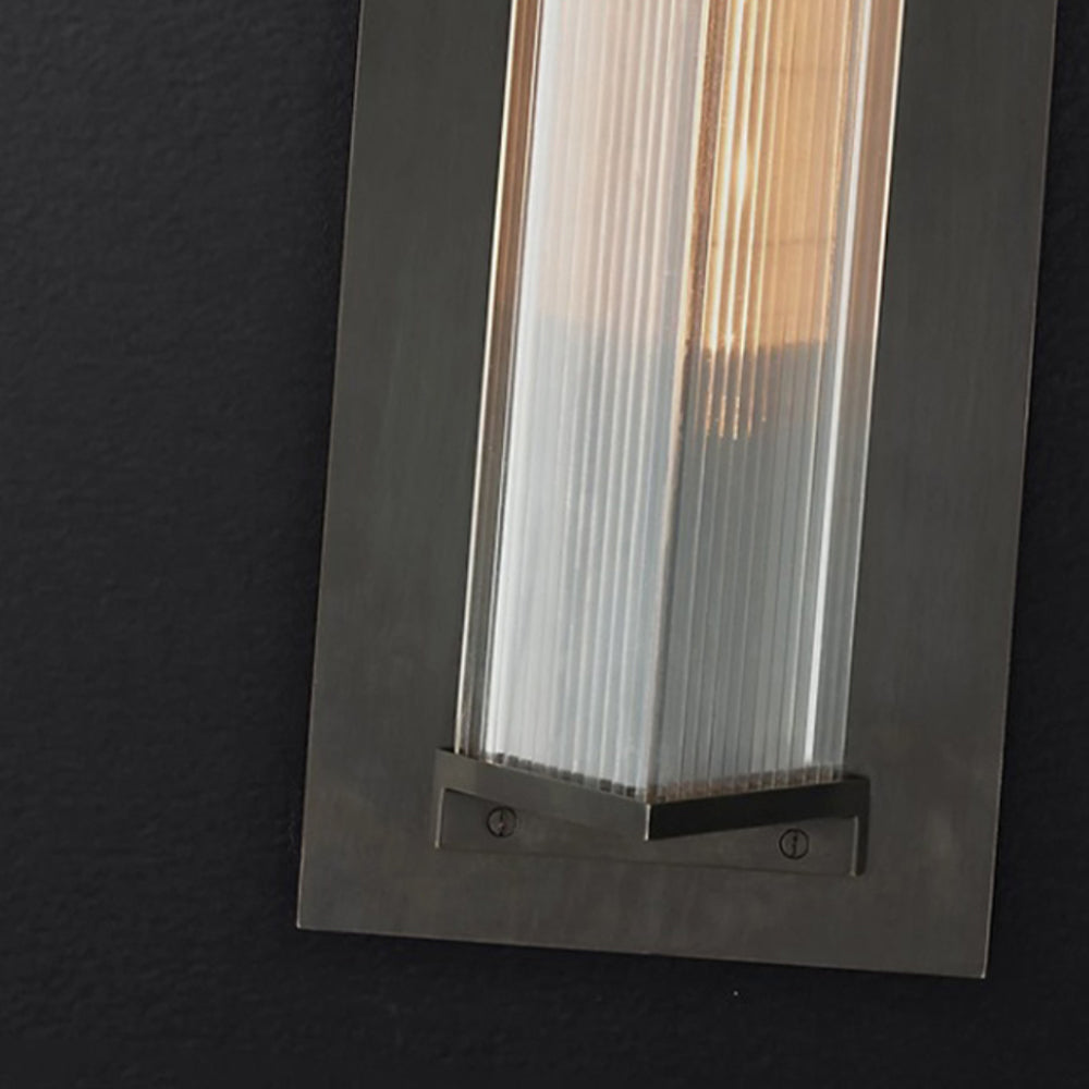 Lower metal frame and ribbed clear shade of Orr wall light