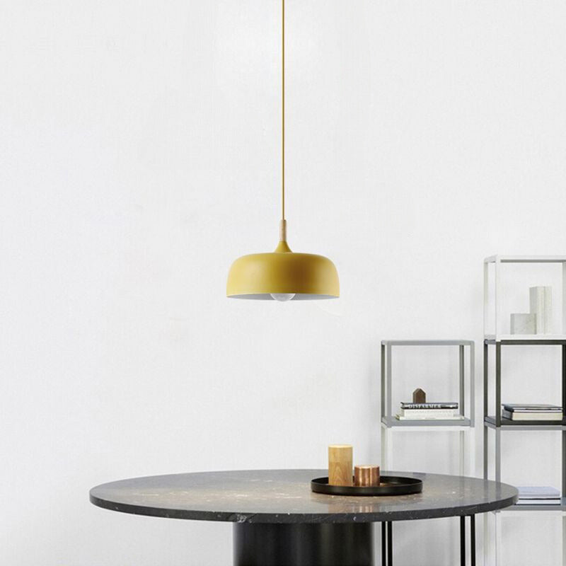 Yellow deeper dome pendant above a dark round table with a tray and candles