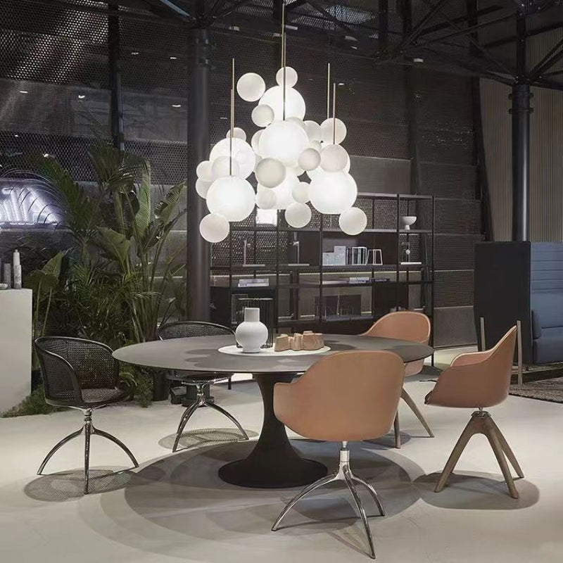 4Head Frosted Glass option photo, several frosted bubble pendants over round dining table with vase, chairs and plants