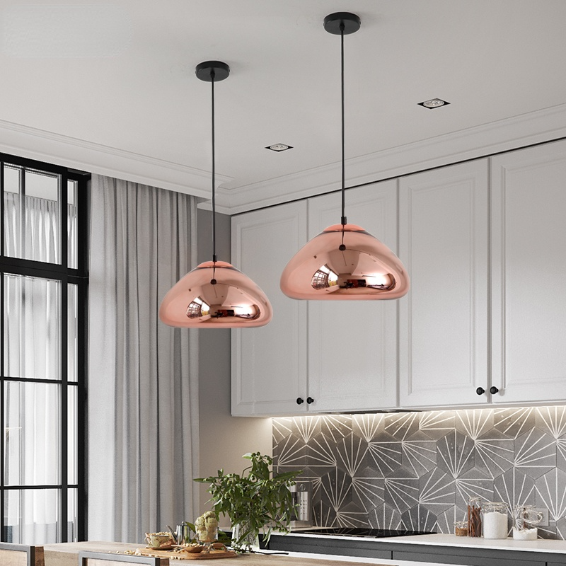 Two rose-gold rounded pendants above a kitchen counter