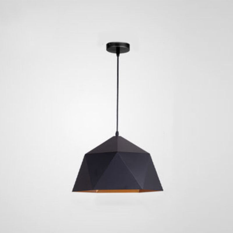 Black geometric pendant shade with a warm metallic-looking lower interior and black ceiling canopy