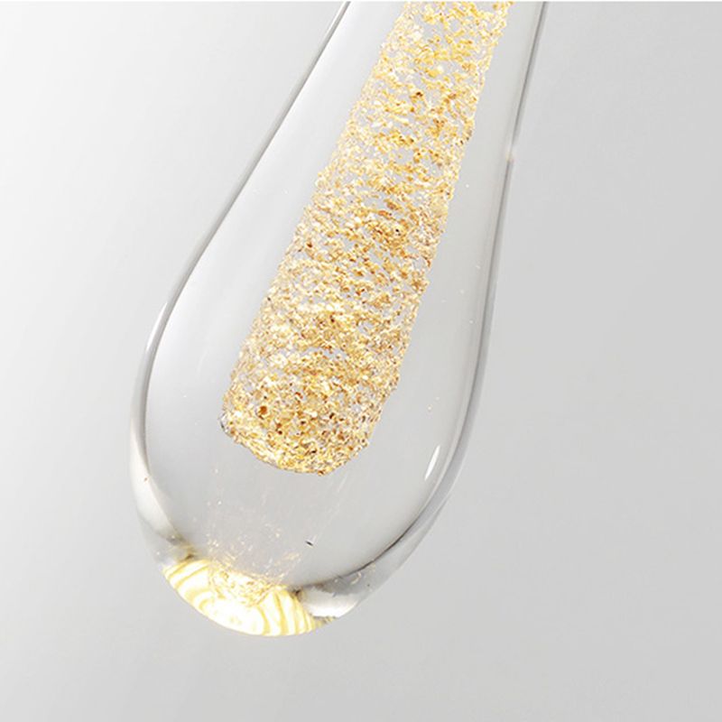 Close view of a clear Hailie teardrop around a textured gold-looking inner element