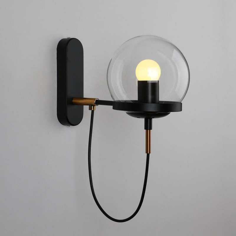 Black Alessio wall light close-up showing clear globe and oval plate