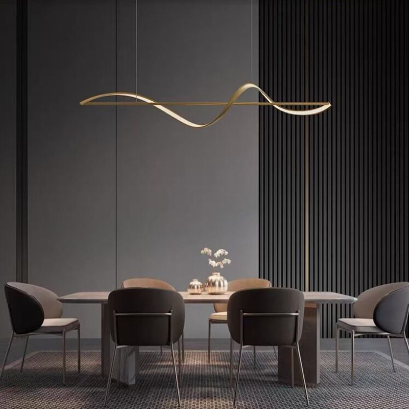 Gold Louise wave pendant above an oval white table with flowers and dining chairs