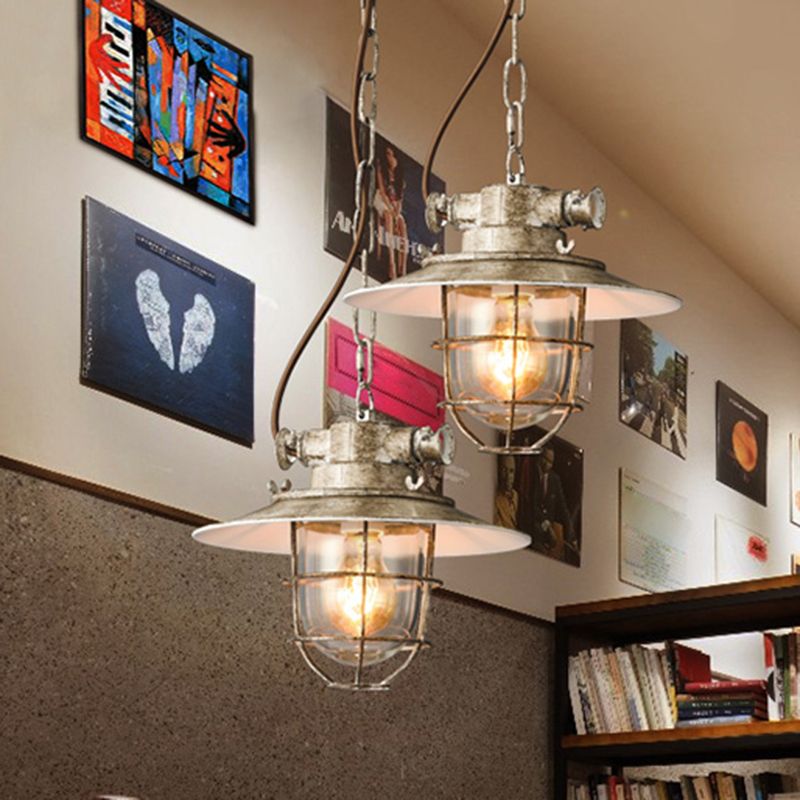 Two pale Alessio cage pendants hanging in an interior with wall art