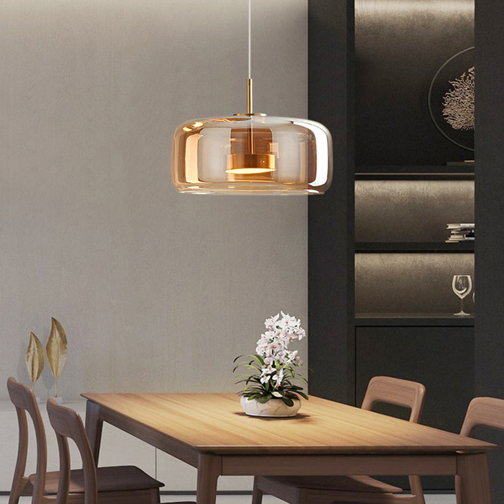 Wide amber Hailie glass pendant with gold-tone inner fitting above wooden dining table with orchid and chairs