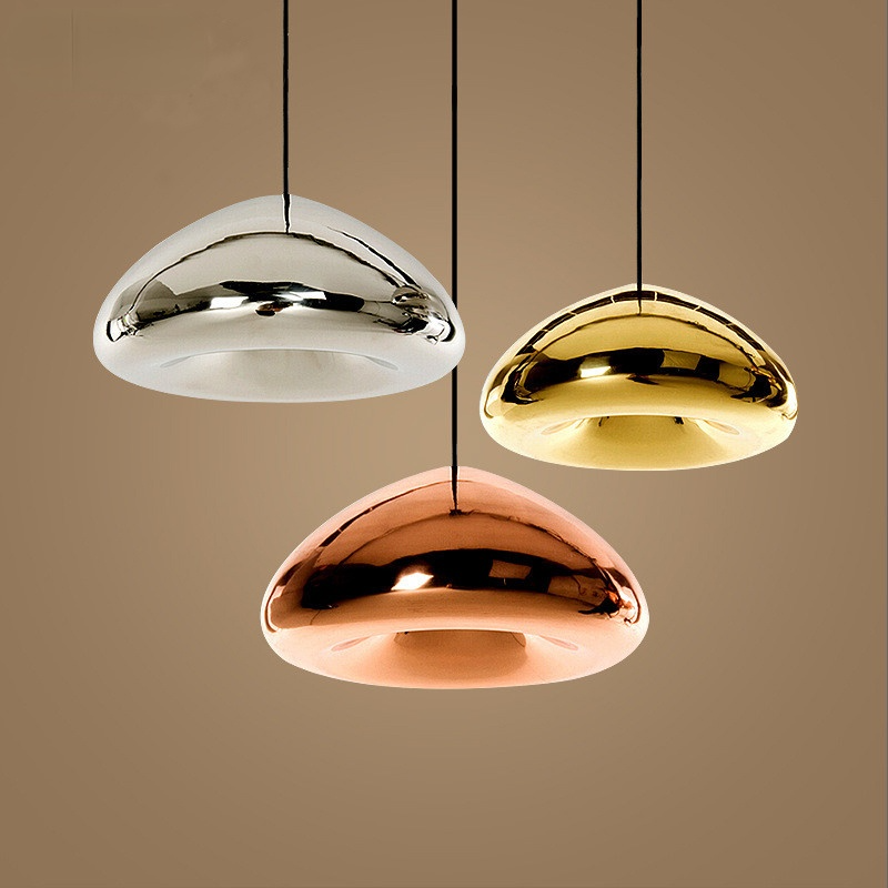 Silver, gold and rose-gold reflective dome pendants against a brown background