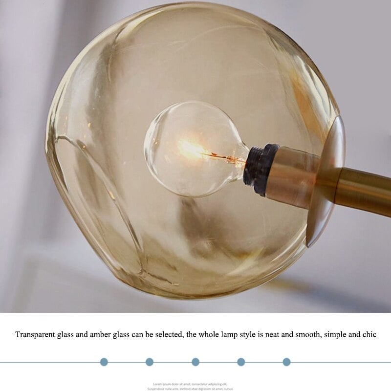 Close warm-tinted open globe with lit bulb and gold support; image caption mentions transparent and amber glass