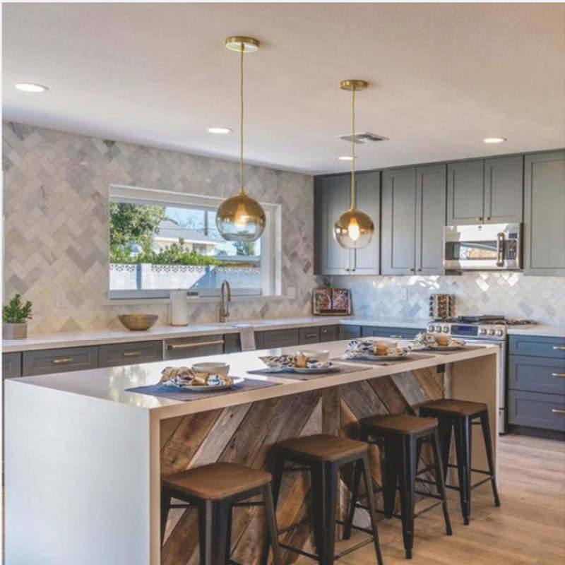 Two gold-gradient globe pendants on separate canopies above a kitchen island