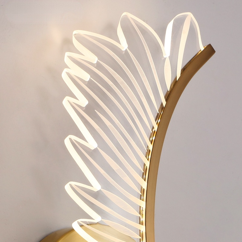 Close-up of Kristy translucent feather outlines with lit edges beside a gold-tone curved strip