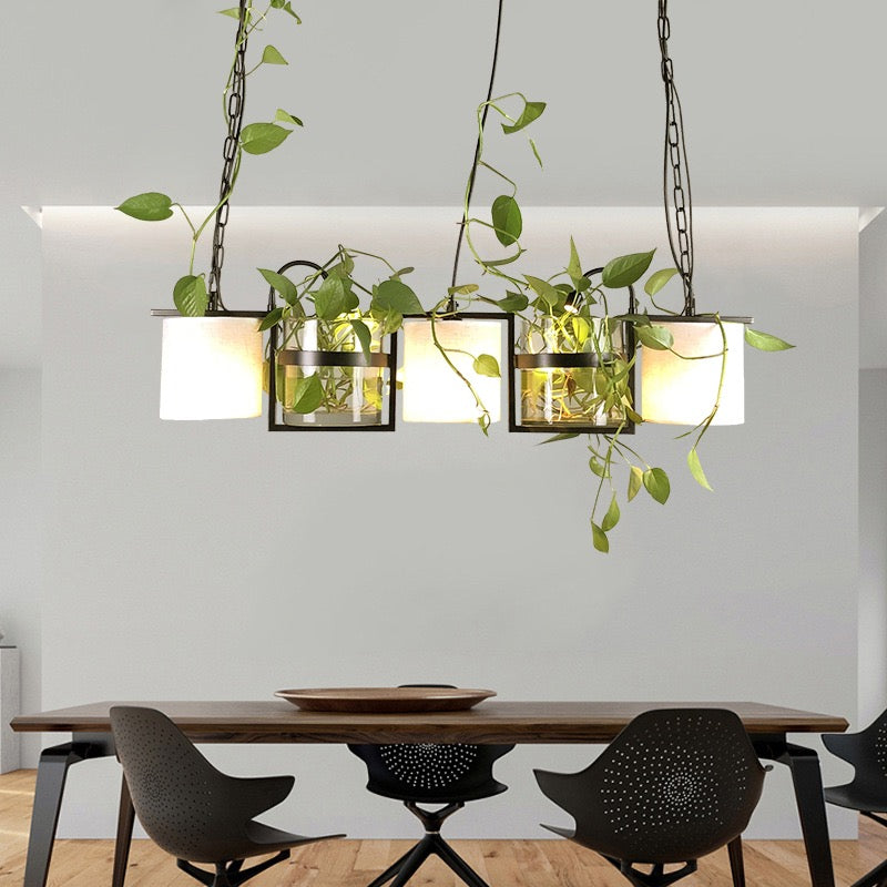 Nest black linear pendant with greenery in a dining setting