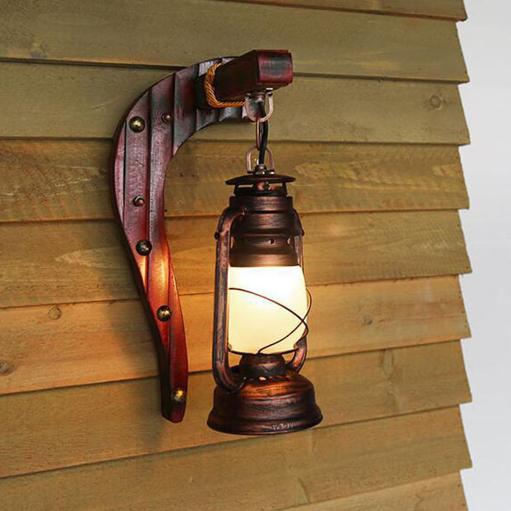 Austin metal lantern suspended from a wood bracket beside a timber-clad wall.
