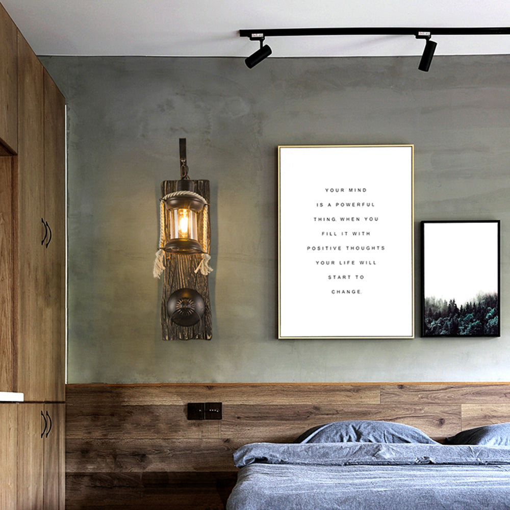 Alessio lantern and ring wall lamp beside framed art above a bed