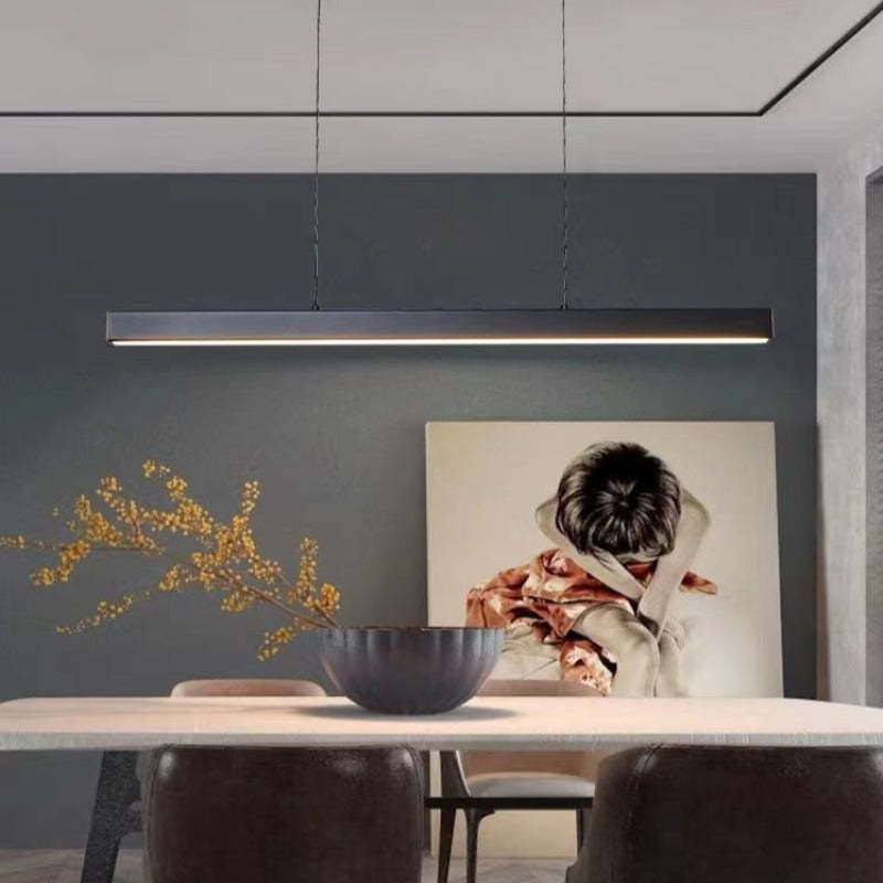 Frontal Black Edge bar over table with ribbed bowl and flowering branch, with portrait on dark blue wall behind