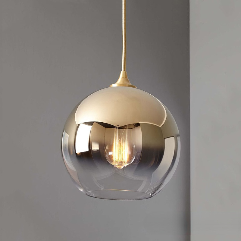 Close gold-gradient glass globe with a lit bulb and clearer lower section