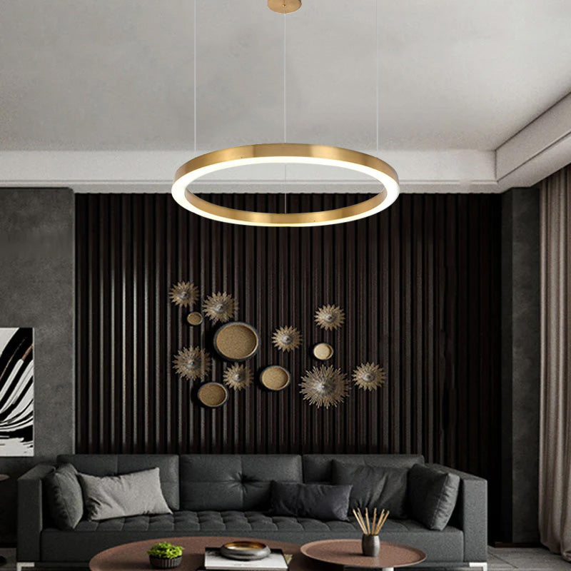 Single gold-colour ring pendant above dark living-room sofa