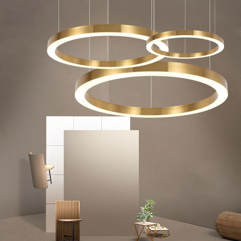 Three separate suspended gold-colour rings at varied heights